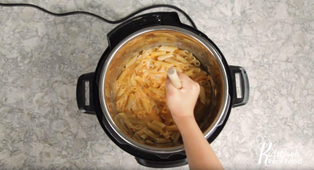 kid stirring mac and cheese