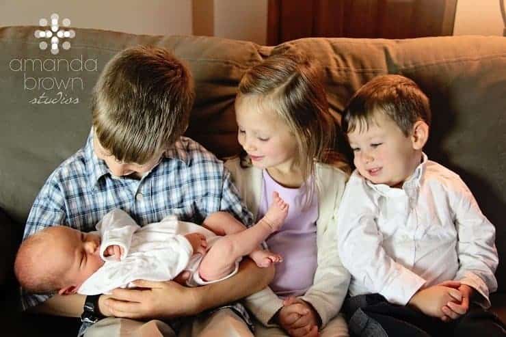 Children holding baby together