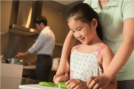 child being guided in safe knife skills