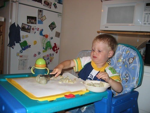 toddler cutting potatoes
