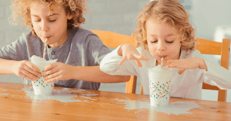 kids spilling milk all over table