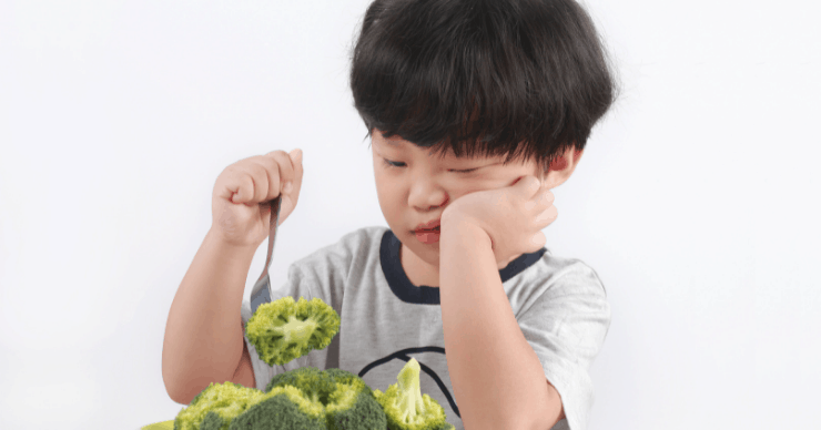 boy picking at broccoli