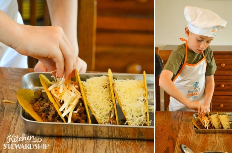 boy sprinkling cheese on sheet pan tacos