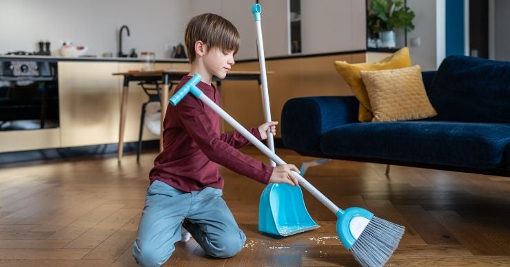 boy sweeping floor