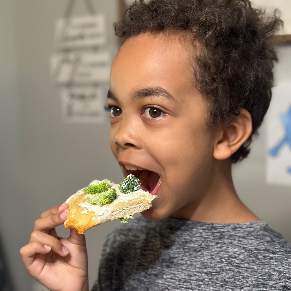 Boy eating the veggie pizza he built