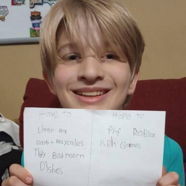 Boy holding up the to-do list he wrote for himself