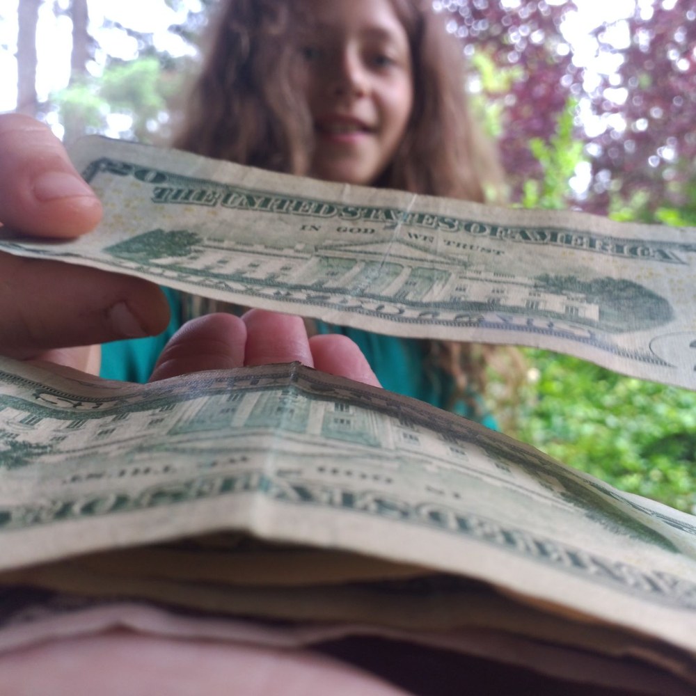 Close-up of a child counting a stack of cash