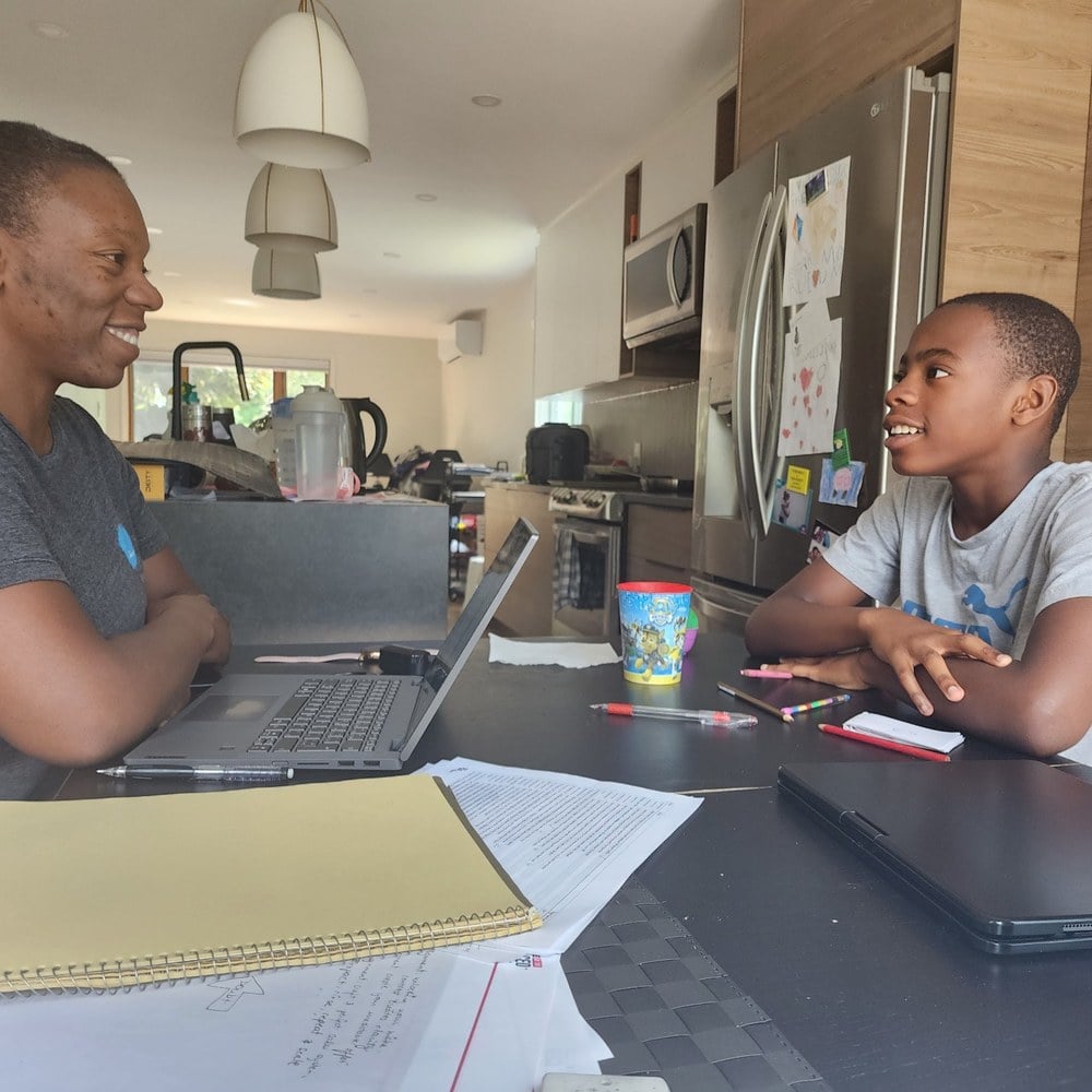 A dad and his teenager working through it together at the kitchen table
