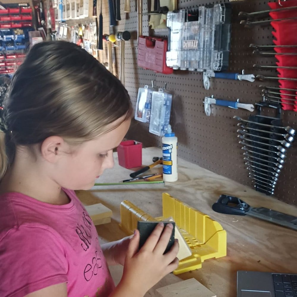 Girl at the workbench building a wooden pencil holder