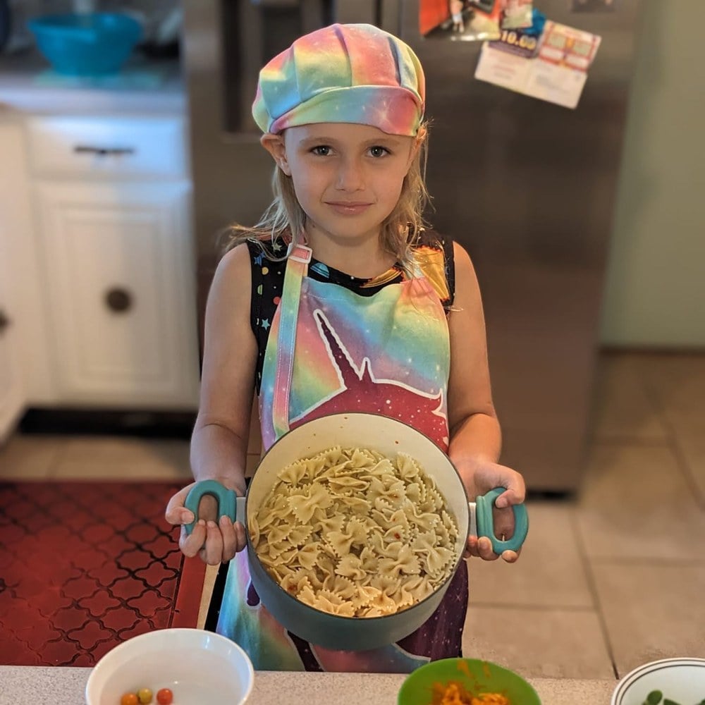 Girl carrying a bowl of pasta to her build-your-own salad bar