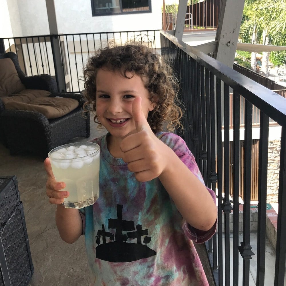 Girl giving a thumbs-up over the lemonade she made