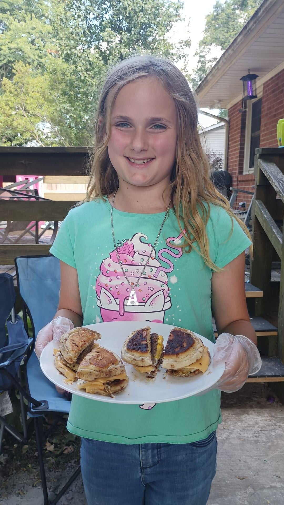 Girl holding out a plate of the breakfast sandwiches she made
