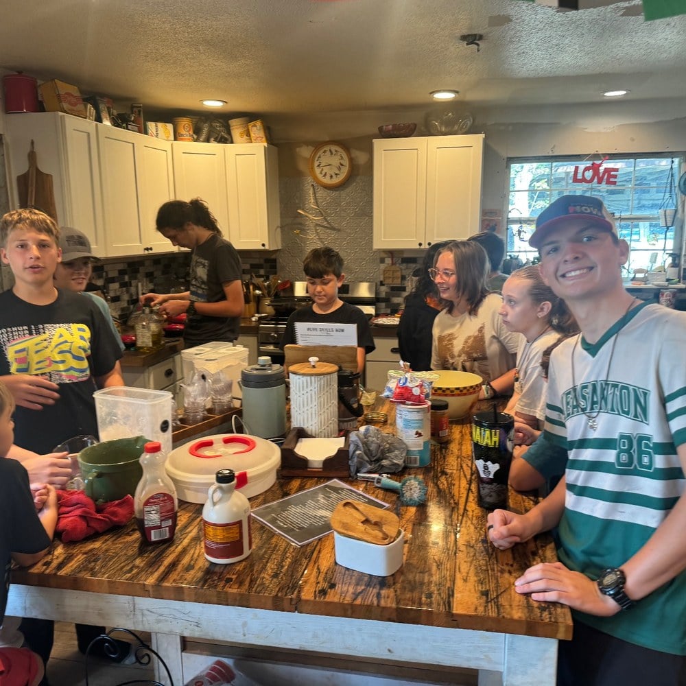 A kitchen full of kids cooking together