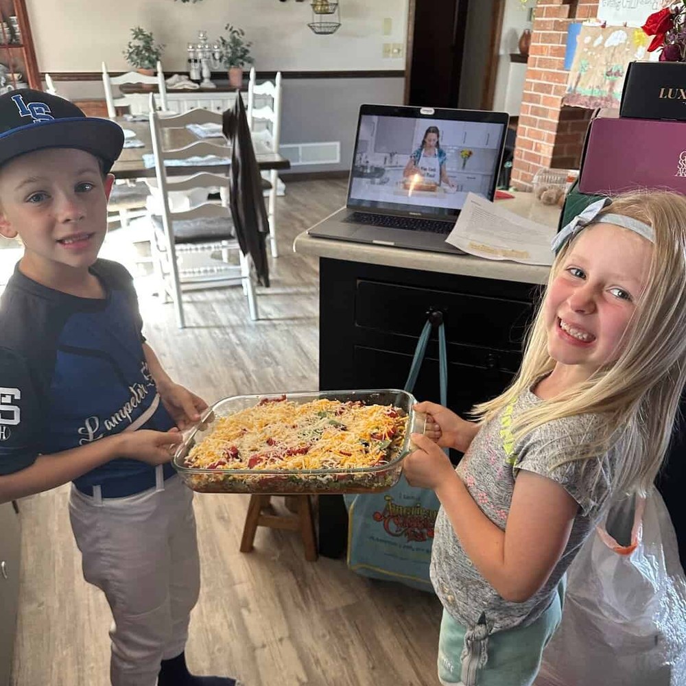 Two children carrying the summer lasagna they made